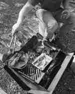 Pria duduk di samping panggangan barbekyu