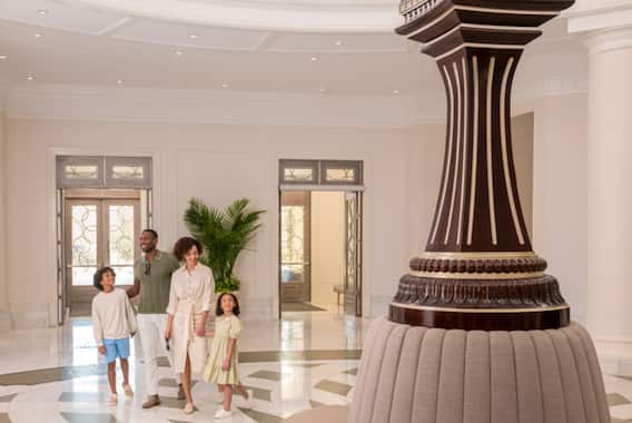 Clock in lobby area with family walking through