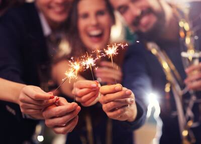 A group of people holding sparklers to the camera
