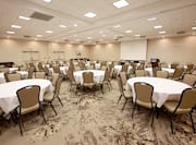 Spacious Ballroom Area with Round Tables, Chairs and Projector Screen