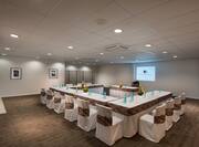 Meeting Space With Wall Art, U-Shaped Table and Chairs, Audio/Visual Equipment, and Speaker's Table