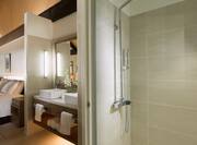 Shower With Glass Doors, Vanity Mirror, Double Sinks, Toiletries, Fresh Towels and View of Bed in Bure