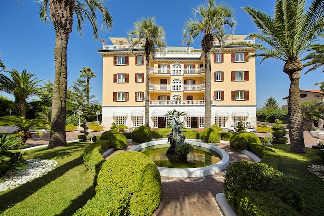 Außenansicht des Hotels mit Garten und Brunnen