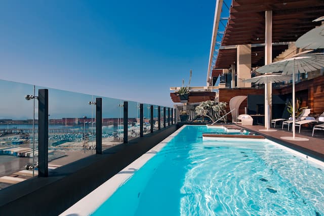 Piscine sur le toit avec chaises longues