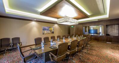 Seating for 15 at Boardroom Table With Water Bottles and Notepads, Wall Art and TV in Meeting Room