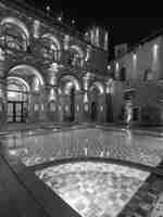 Immagine notturna dell'esterno della piscina e delle sedie a sdraio.