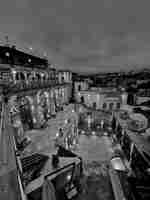 Immagine notturna dell'esterno della piscina e delle cabine, oltre al retro dell'hotel.