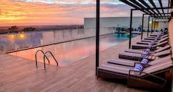 Outdoor Rooftop Swimming Pool with Deck Chairs at Dusk