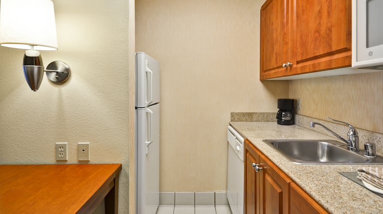 Detailed View of Kitchen With Fridge, Dishwasher, Coffee Maker, Sink, and Microwave in Studio Kitchen