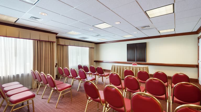 Caesar Rodney Meeting Room With Large Windows and Red Chairs Arranged Theater Style and Facing Presenter's Table