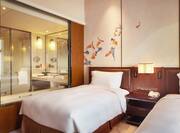 Twin Deluxe Room with double beds and transparent window view of bathroom and shower
