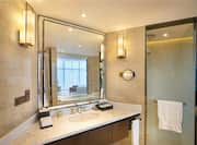 Executive Suite Bath With Sink, Amenities, Fresh Towels, Shower With Glass Doors, and Vanity With Reflection of Bedroom