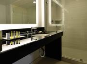  Detailed View of Large Vanity Mirror, Sink, Toiletries, and Shower With Glass Doors in Non-Smoking Presidential Suite Bathroom