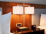Detailed View of Bedside Table Between Two Beds, Illuminated Lamps, and Alarm Clock/Radio With MP3 Connection