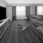 Suite Presidential non fumatori 2 Divano, tavolino, TV, finestre con tende velate, poltrona e ottomana in una camera