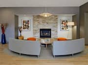 Wall Art, Brick Fireplace, Table, Ottoman, Floor Lamp and Sofas in  Sitting Area