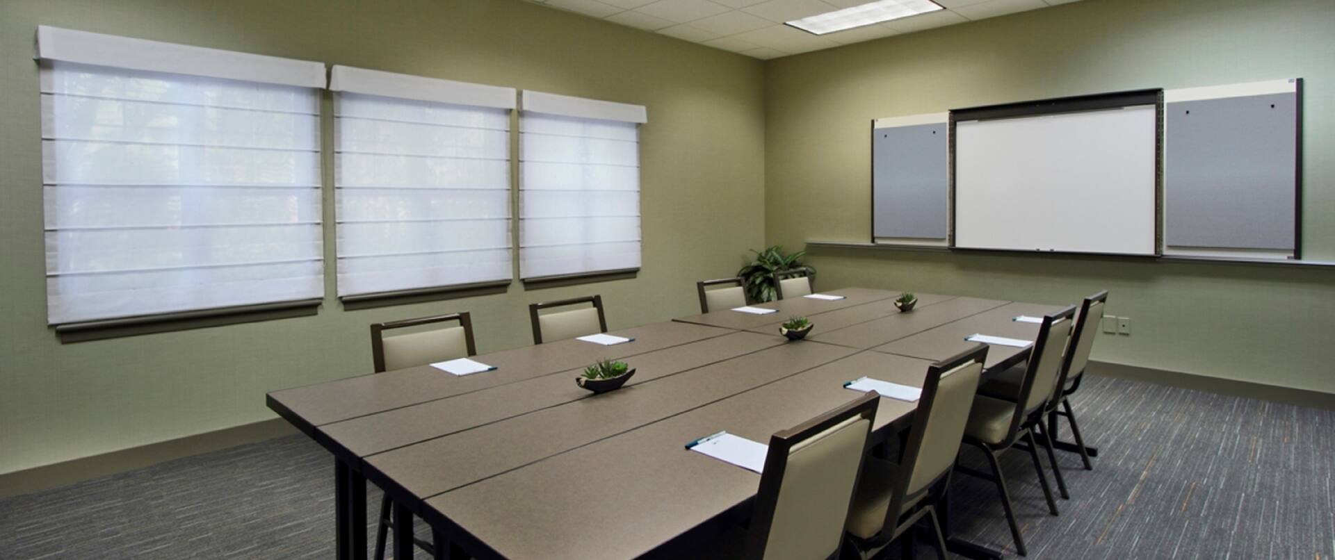 Cypress Room in Boardroom Setup With Seating for 8 Facing Whiteboard