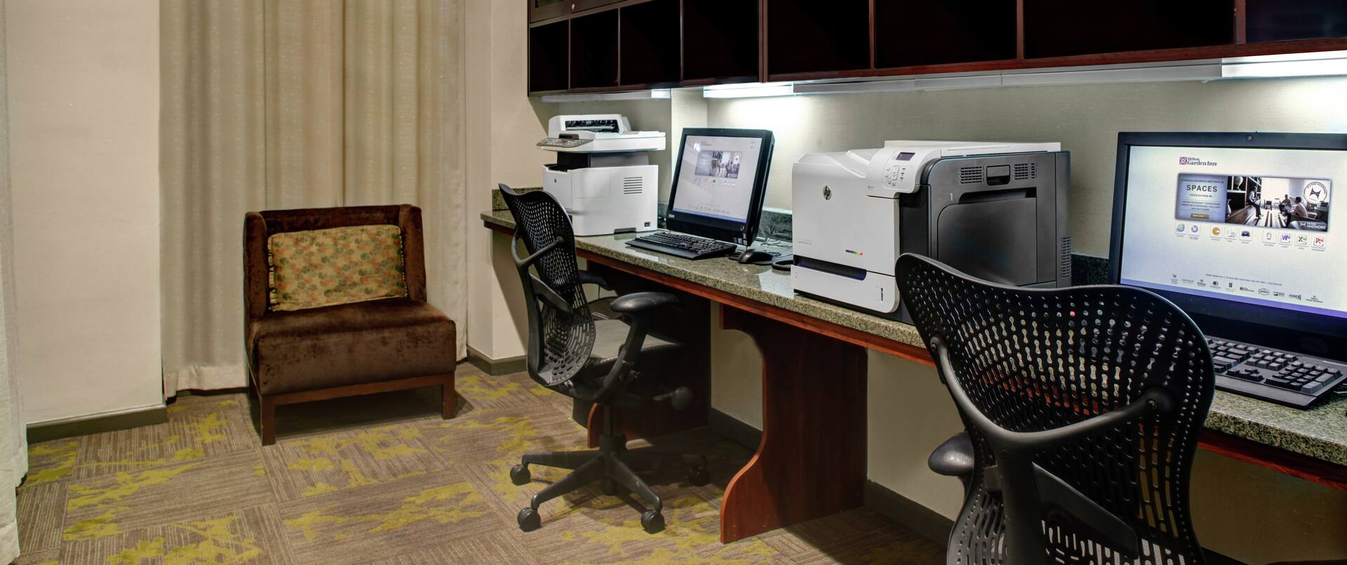 Business Center With Lounge Chair, Window With Sheer Drape, Two Computer Workstations, Ergonomic Chairs, Printer, and Fax/Copier