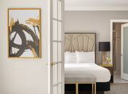 entrance to suite bedroom in neutral color palette and shot of bed