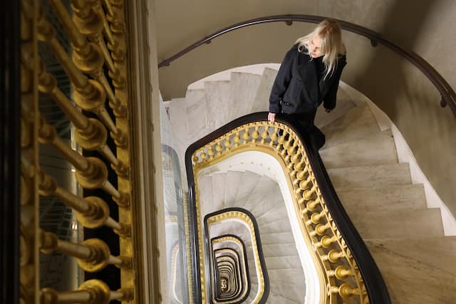 Woman Walking up the Stairs in Lobby Area