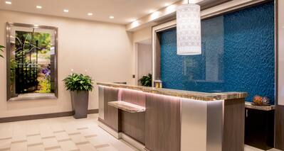 Front Desk Reception Area with Blue Mural and Wall Art