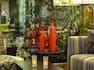 Detailed View of Orange Vases on Table By Window, Lounge Seating and Candles on Coffee Table in Lobby