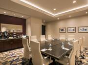 Square Boardroom Setup With Seating for 10, Mirror Above Beverage Service Area, and Wall Art