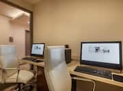Business Center With Two Computer Workstations, White Chairs, and Printer