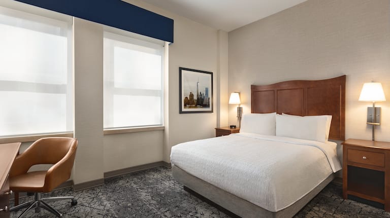 Inviting Guest Room with ample space featuring comfortable Queen bed and in-room Work Desk