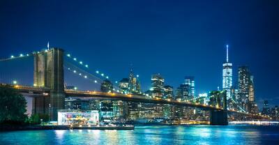 Illuminated Brooklyn Bridge and New York Skyline at Night