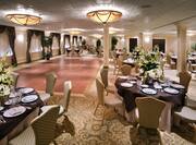 Dance Floor Surrounded by Dining Tables With Place Settings and Flowers on Linens and Windows With Closed Drapes in The Regency Ballroom 