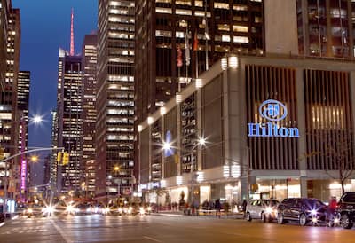 Exterior shot of the New York Hilton Midtown at night.