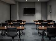Classroom Setup in Meeting Room With Drinking Glasses on Tables, Chairs, TV and Wall Art