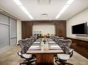 Boardroom Formal Set Up Table with Notepads, Office Chairs and Wall Mounted HDTV