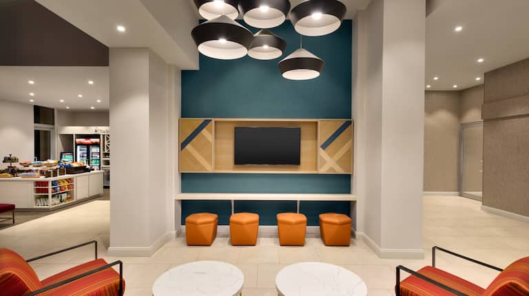 Lobby Seating Area with Wall Mounted HDTV, Armchairs and Small Coffee Tables