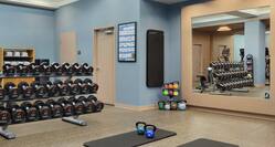 Spacious on-site fitness center fully equipped with free weights.