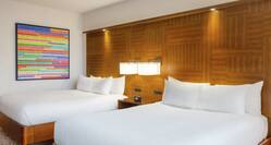 Bright guestroom featuring two comfortable queen beds.