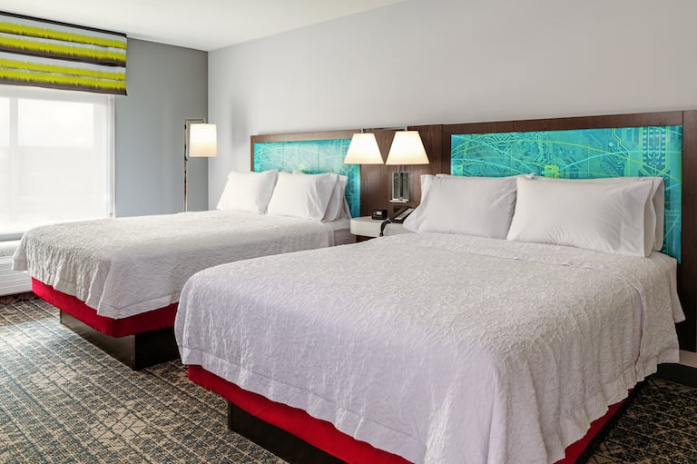 Una camera di un hotel Hampton con due letti queen size uno accanto all'altro. 