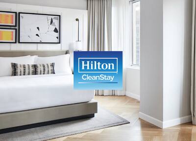 Hilton CleanStay logo over an image of a hotel bedroom
