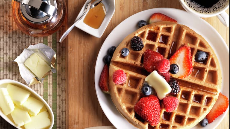 Waffle Plate with Berries and Butter and a Cup of Coffee