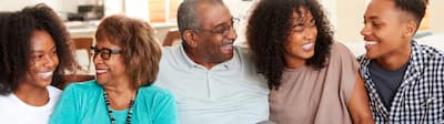 Family on couch looking at one another and smiling