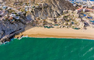 a bird's eye view of a hotel resort built into a cliff on a beach