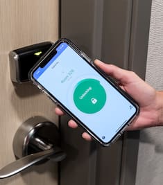 Image of a phone unlocking hotel room door