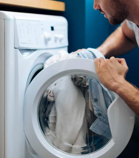 Man putting laundry into machine