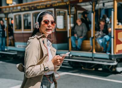 Young woman in San Francisco with trolley in the background