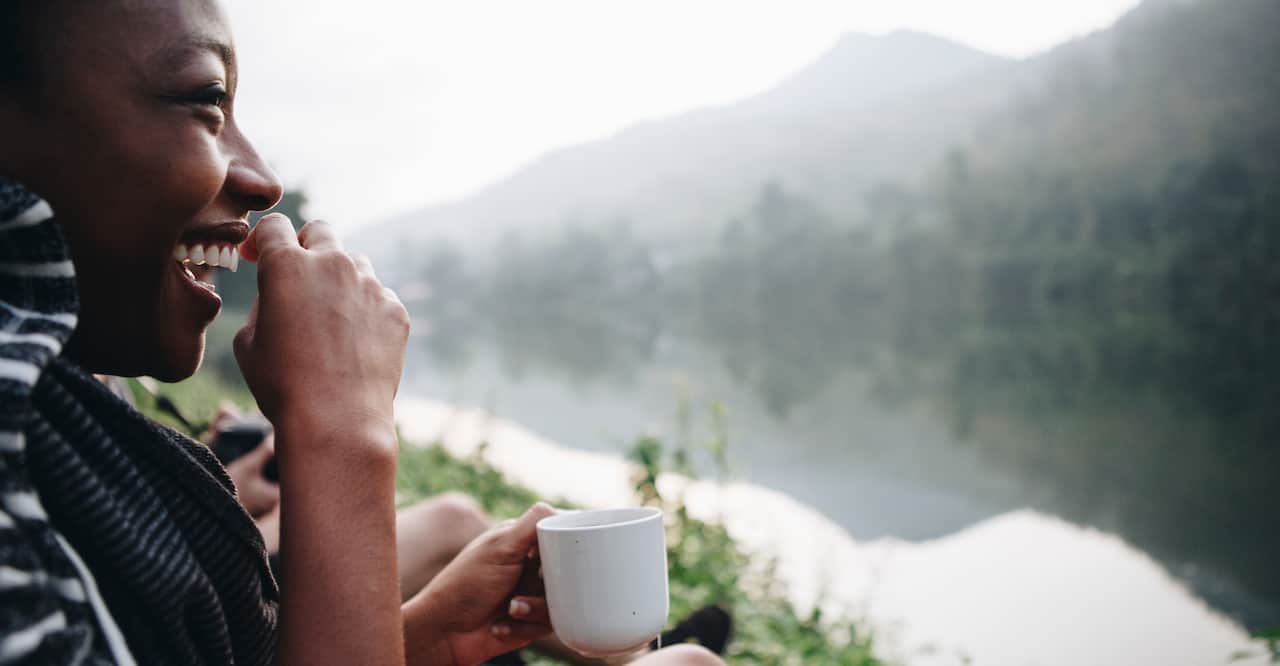 Woman enjoying coffee by river