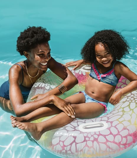 Mother and daughter swimming in pool