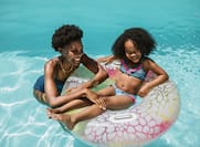 Mother and daughter swimming in pool