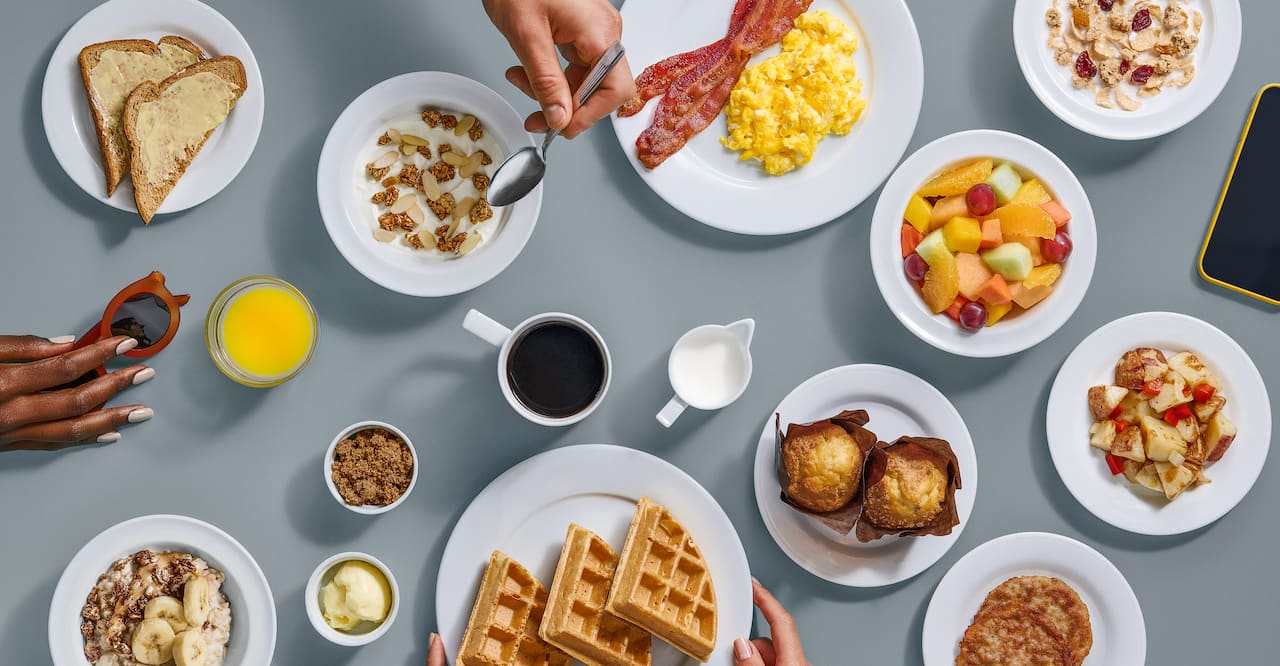 A selection of breakfast dishes set against a gray background