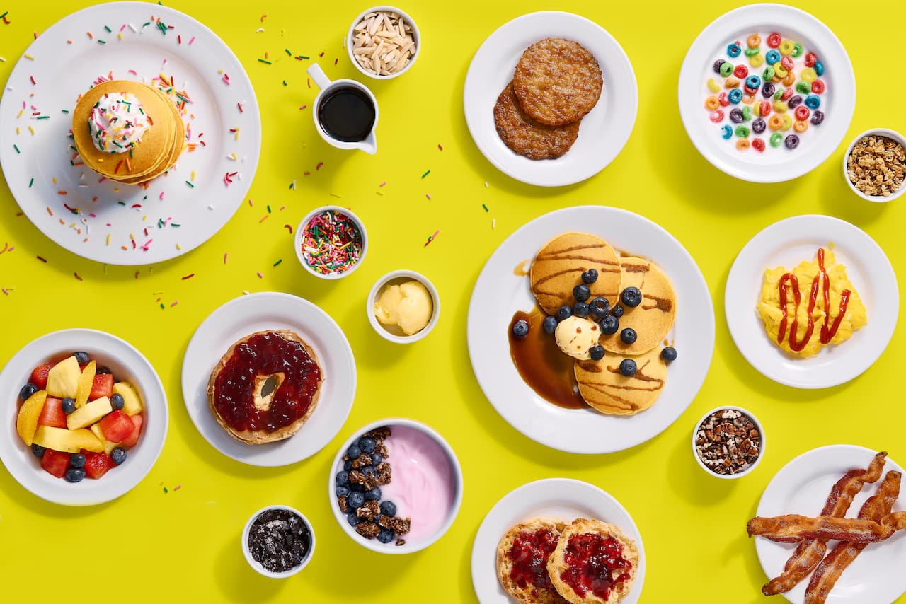 A selection of breakfast dishes set above a yellow background